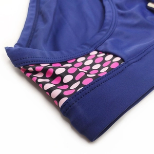 Detailed close-up showing reinforced seams and polka dot print on navy blue swimwear