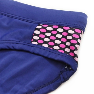 Detail view of navy blue swimwear fabric with polka dot side stitching and elastic seams