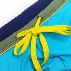 Detail of multi-color swimwear waist with bright yellow drawstring and metal eyelets