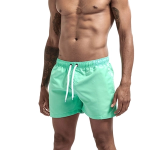 Detail of mint green quick-dry beach shorts with elastic drawstring waist and white cords