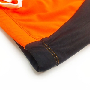 Detail of professional quick-dry swim trunks with orange contrast stitching and drawstring