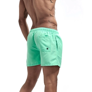Detail view of mint green quick-dry beach shorts with elastic waist and back pocket