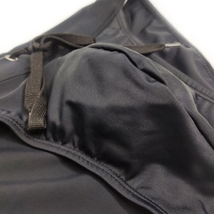 Close-up of men's low-waist swim briefs featuring ergonomic front pouch and drawstring