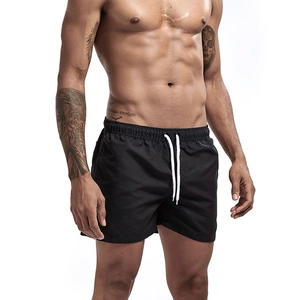 Detail of men's black quick-dry swim shorts with elastic waistband and white drawstring