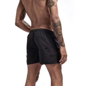 Detail view of mens black quick-dry beach shorts featuring an elastic waist and back button pocket