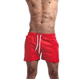 Detail of red quick-dry swim trunks showing the drawstring waist and fabric texture