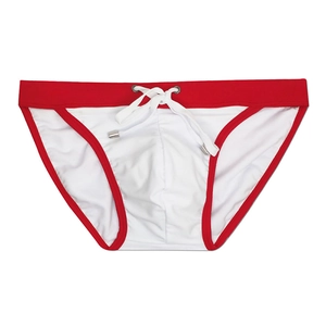 Detail view of men's white bikini swimwear with red contrast trim and drawstring tips