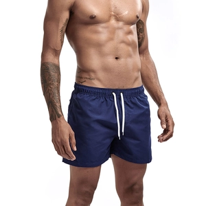 Detail of dark blue quick-dry swim trunks with elastic waistband and white drawstrings