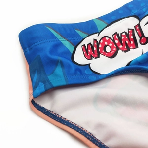 Detail of blue men's swim briefs showing 'WOW!' comic print and pink elastic trim