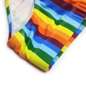 Macro view of rainbow striped swimwear fabric showing high-elasticity and durable double stitching