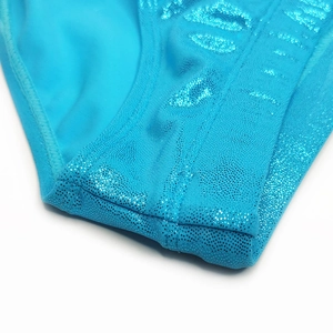 Close-up of bright blue sequin men swimwear fabric with metallic shimmer and stitching