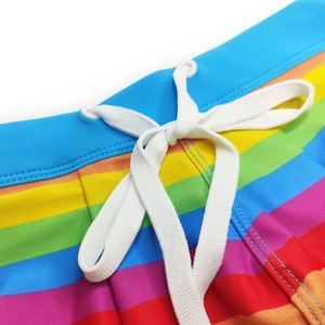 Detail of multi-color rainbow striped swim trunks featuring a white adjustable drawstring