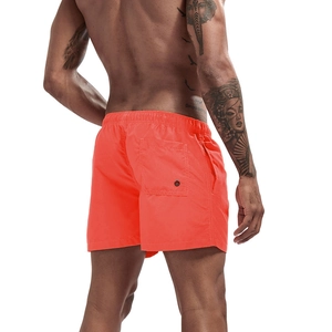 Detail view of quick-dry orange swim shorts with elastic waistband and back pocket