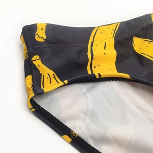 Gros plan détaillé des coutures et de l'imprimé banane sur ce slip de bain noir pour homme