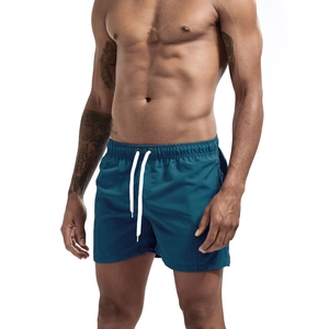 Detail of teal quick-dry beach shorts with elastic waistband and white drawstring