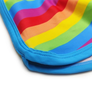 Close-up of rainbow stripe fabric with blue elastic edges and double-needle stitching detail