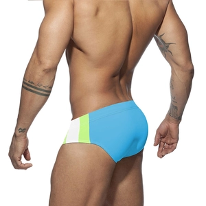 Rear view of men's athletic swim briefs showing side patchwork of white and neon green
