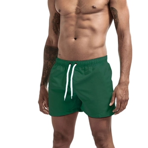 Detail of dark green quick-dry shorts featuring an elastic waist and white drawstring