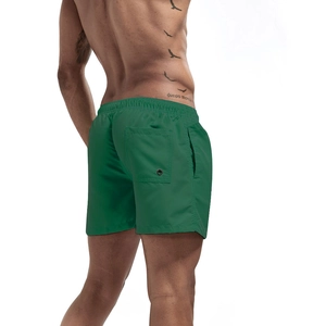 Detail of green quick-dry beach shorts showing elastic waistband and back pocket with vent