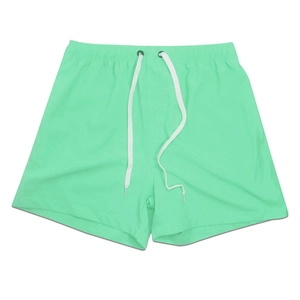 Detail of mint green quick-dry beach shorts with elastic waistband and white drawstring