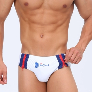 Detail of men's low-rise swim briefs with side red zippers and blue splicing design