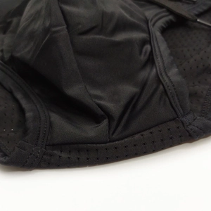 Detailed close-up of breathable mesh stitching and elastic fabric on men's black swim briefs