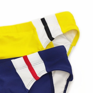 Detailed stitching of contrast panel men's swim trunks in yellow and dark blue colors