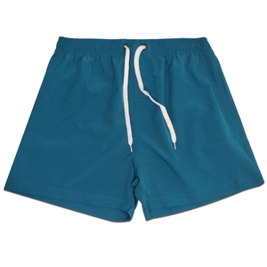 Detail of teal quick-dry beach shorts featuring elastic drawstring waist and side pockets