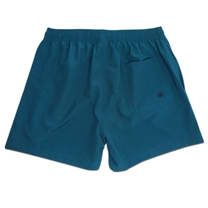 Detailed back view of teal swim shorts featuring a square pocket and metal drainage eyelet