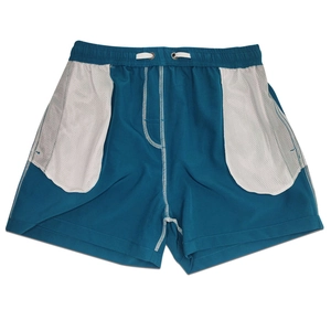 Detail of turquoise quick-dry shorts featuring white mesh pockets and drawstring