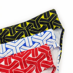 Close-up of men's swim briefs featuring 3D geometric Y-patterns in yellow, blue and red
