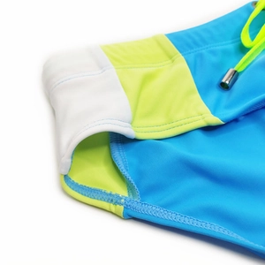 Detail of color-block swim briefs with side stitching, neon drawstring and metal tips