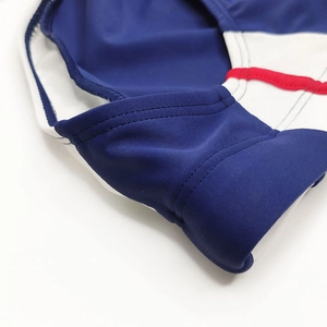 Close-up of color-block swim trunks featuring precise flatlock stitching and elastic knit fabric