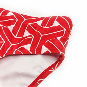 Macro shot of red swimwear with white geometric print and reinforced flat stitching