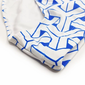 Macro detail of white swimwear with blue honeycomb print and flat double stitching