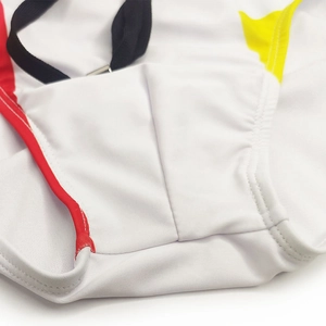Detail of color-block swim briefs with white base, red piping and yellow panel accents