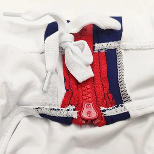 Detail of men's swim briefs showing red zipper, white drawstring and tricolor waist fabric