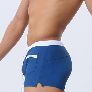 Detail of royal blue swim trunks showing white zipper pocket and drawstring waist