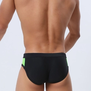 Rear view of men's athletic swim briefs in black with neon green contrast side panels