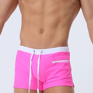 Detail of pink men's swimming trunks featuring a white drawstring and a side zipper pocket