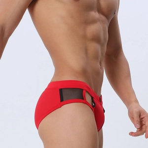 Close-up of red men's swim briefs featuring black mesh side panels and hollow-out design