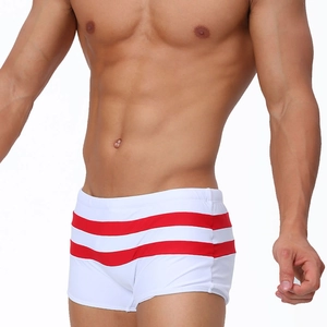 Detail of men's white striped swim trunks with thick red bands and athletic fit