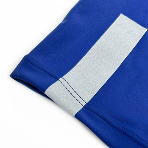 Close-up of swim shorts hem featuring a reflective silver band and blue elastic fabric