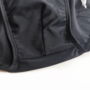 Macro shot of men's black swim briefs showing stitching details and drawstring texture