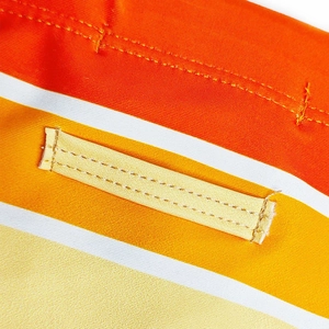 Detailed close-up of vibrant orange and yellow striped fabric with reinforced stitching