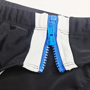 Detail of blue side zipper on black high-stretch men's swimwear with white contrast panel