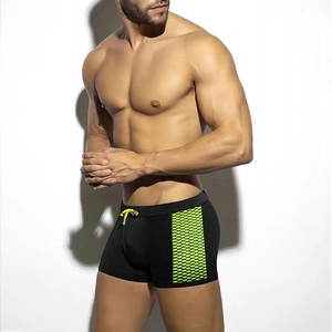 Men's quick-dry swim trunks with black fabric and neon green honeycomb mesh side panels
