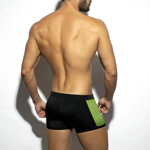Rear view of black mens swim trunks featuring neon green honeycomb textured side panels