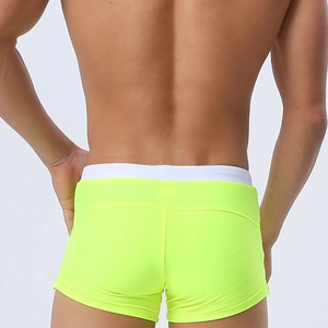 Rear view of fluorescent yellow men's swimming trunks with ergonomic back stitching details