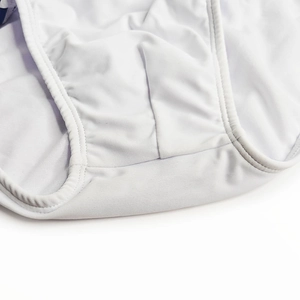 Gros plan sur la double couture renforcée et le tissu blanc doux de ce maillot de bain
